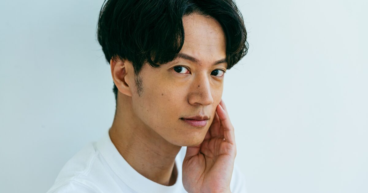 頬に手を当ててスキンケア効果を実感する男性