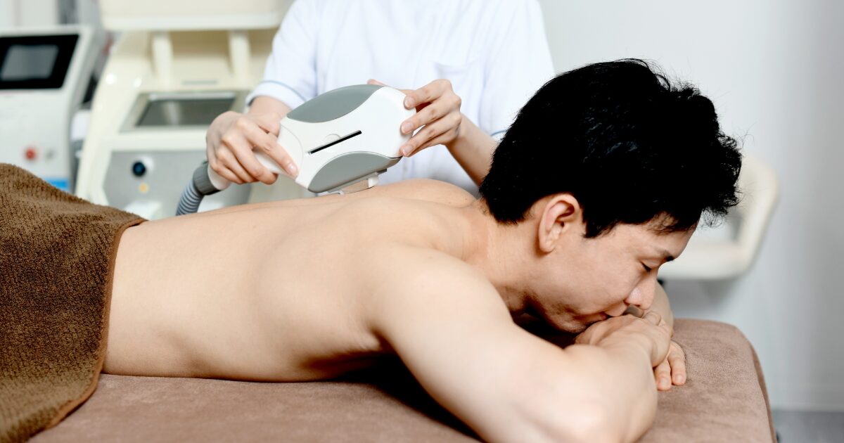 背中の脱毛施術を受ける男性の様子